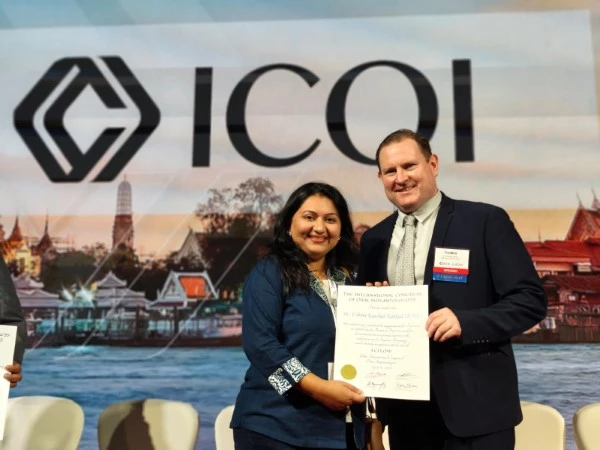 Dr. Ushma Kakkad receiving her ICOI - USA Certified Implantologist certificate, showcasing expertise at the best dental clinic in Surat.
